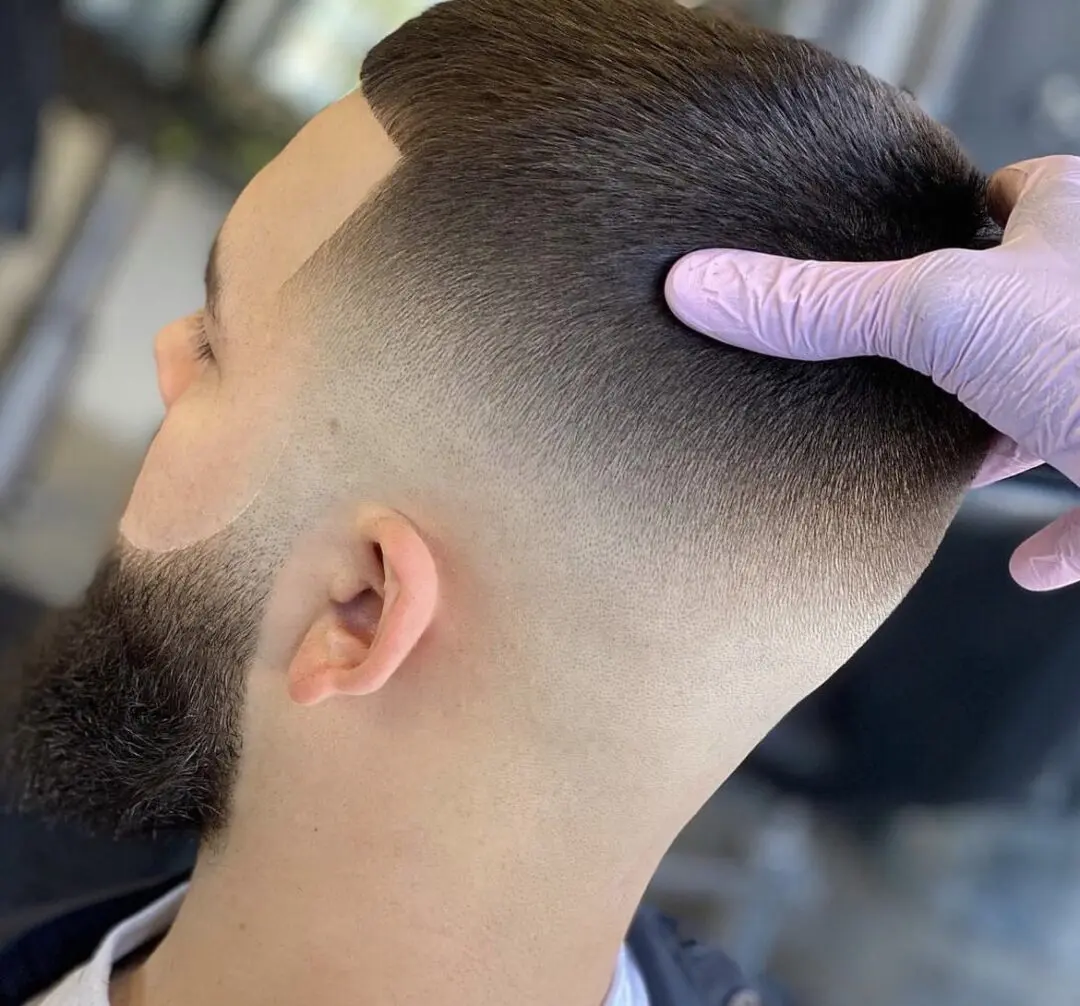 Fresh fade haircut with sharp edges and clean beard line.