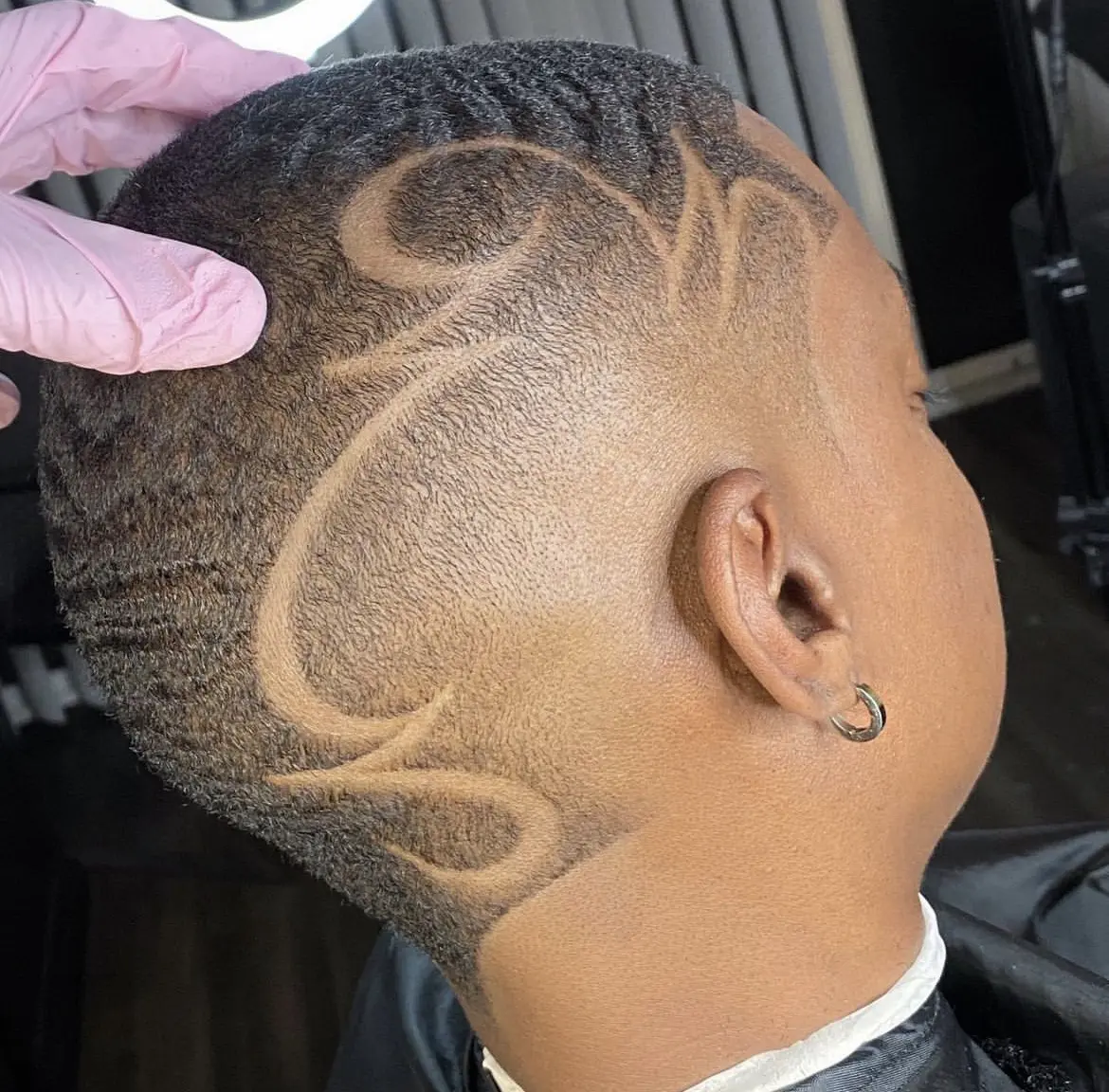 Intricate wave pattern haircut with artistic shaved designs.
