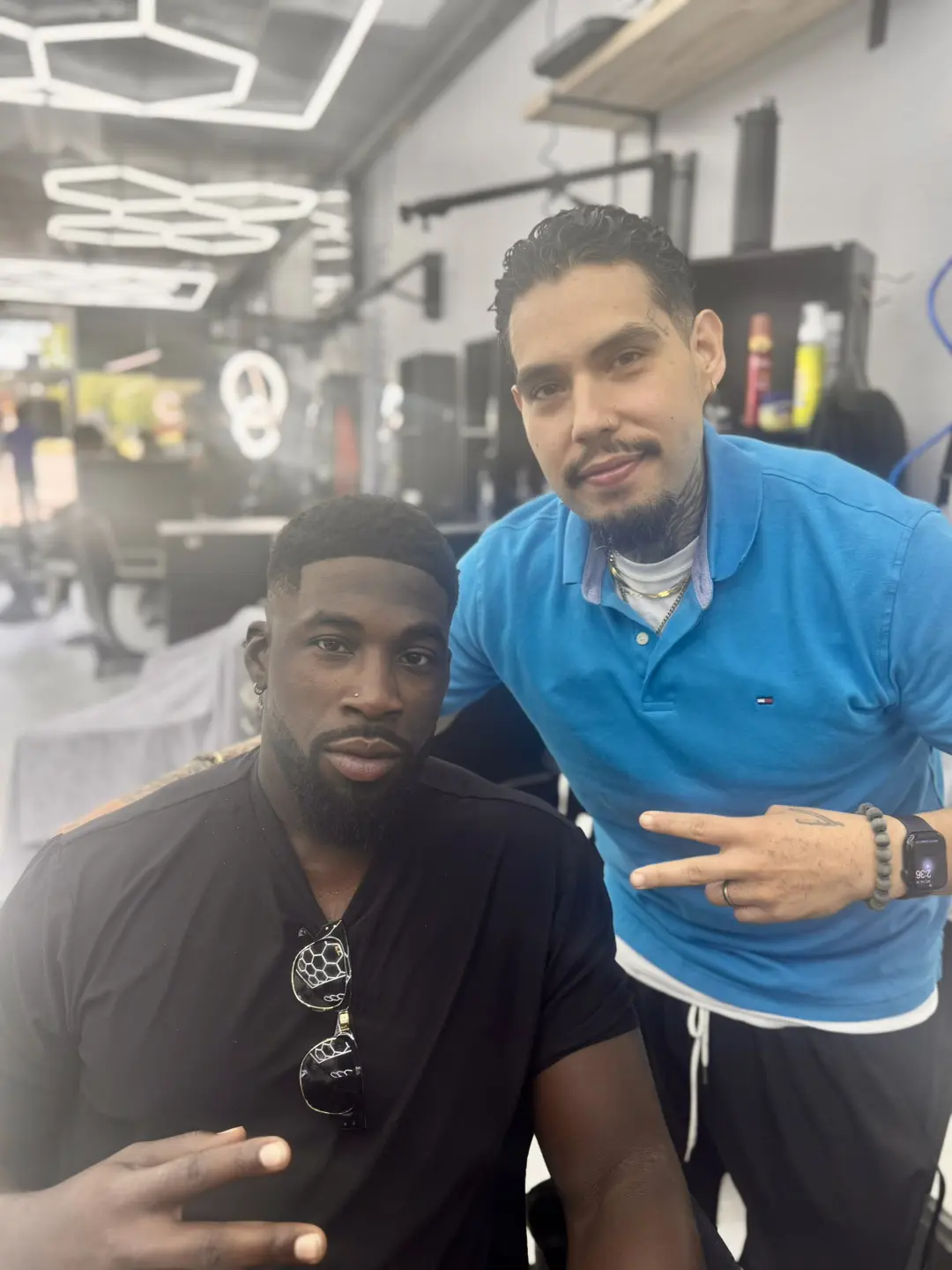 Two men posing together in a casual indoor setting.