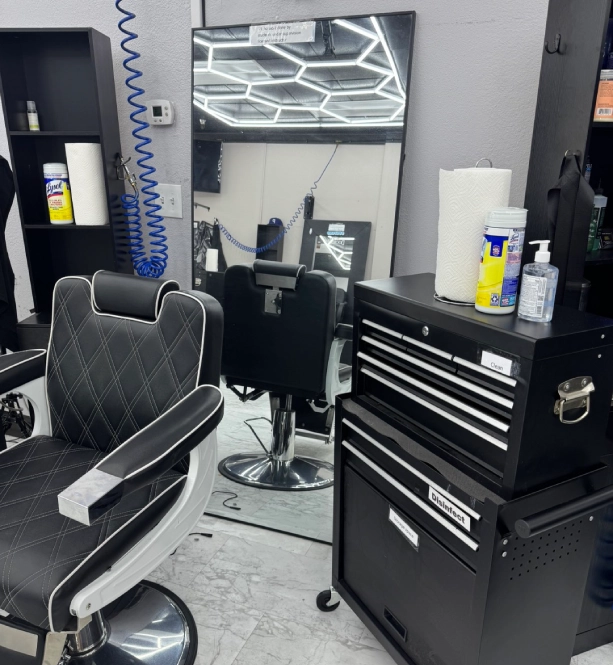 A modern barber chair and tool chest in a clean barbershop.